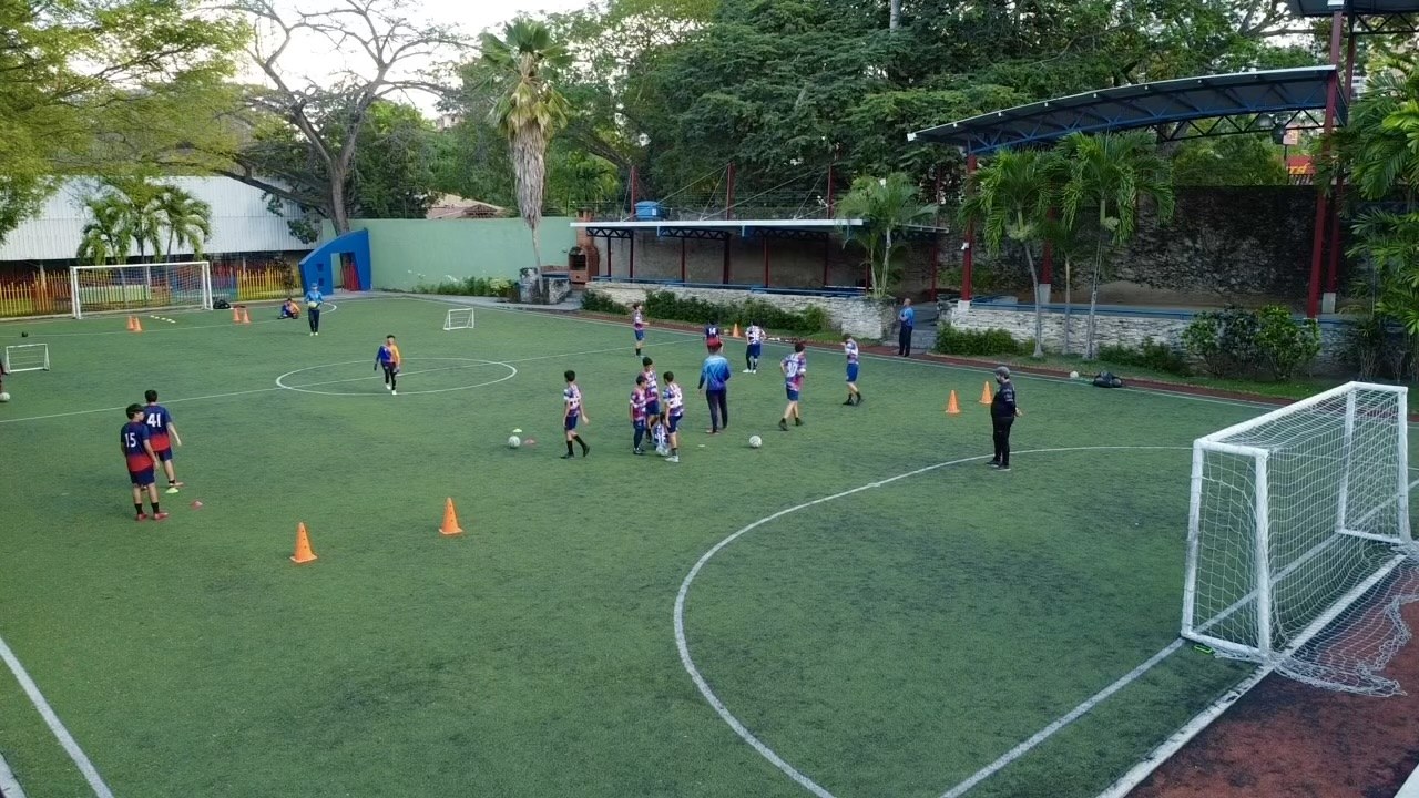 Estudiantes de la Academia de Fútbol entrenando en la cancha sintética del colegio